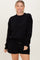 woman wearing a black oversized sweatshirt with long sleeves and coordinating black shorts