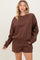 woman wearing a brown oversized sweatshirt and matching shorts