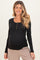 woman wearing a black long sleeve maternity top with button details and a visible baby bump