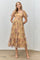 woman wearing a yellow floral midi dress with puff sleeves and a tiered skirt, standing against a neutral background