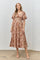 woman wearing a brown floral midi dress with puff sleeves and a smocked bodice