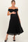 woman wearing a black off-the-shoulder maternity dress with pleated detail and holding her baby bump