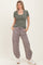 woman wearing a striped short sleeve top in green and white and gray relaxed joggers with elastic cuffs