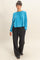 woman wearing a cropped blue ribbed sweater and black wide-leg pants