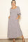 woman wearing a floral print maxi dress with a square neckline and puff sleeves, posing with hands in pockets