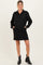 woman wearing a black maternity pullover dress with a quarter zip and two front pockets