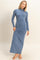 woman wearing a long sleeve blue maxi dress with a high neckline and form-fitting silhouette