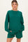 woman wearing a green oversized maternity sweatshirt and matching shorts with pockets
