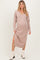 woman wearing a light pink v-neck long sleeve maternity dress with side slits and standing confidently
