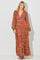 woman wearing an orange floral maxi dress with long sleeves and a deep v-neckline