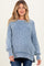 woman wearing a light blue striped maternity sweater with a relaxed fit and side slits
