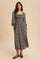 woman wearing a black floral maxi dress with puff sleeves and a smocked bodice