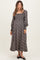 woman wearing a black floral long sleeve maternity dress with a square neckline and flowing skirt, holding her baby bump