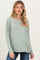 woman wearing a light green long sleeve maternity top with a relaxed fit and flowing silhouette