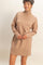 woman wearing a tan turtleneck sweater dress with ribbed detailing and long sleeves