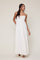 woman wearing a white maxi dress with spaghetti straps and a tie detail at the neckline