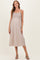 woman wearing a striped beige maternity dress with adjustable straps and a visible baby bump