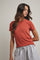 woman wearing a rust colored short sleeve t-shirt and gray sweatpants