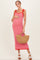 woman wearing a red and white striped maternity maxi dress with tie shoulder details and holding a straw bag, showing her baby bump