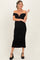woman wearing a black off-the-shoulder maternity dress with ruching and a fitted silhouette, showing her baby bump