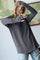woman wearing a loose-fitting gray ribbed long sleeve top with thumbholes and distressed jeans