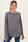 woman wearing a dark gray ribbed maternity sweater with a relaxed fit and long sleeves, showing her baby bump
