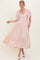 woman wearing a light pink puff sleeve maxi dress with gathered bodice and tiered hem