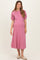 woman wearing a pink short sleeve maternity dress with puffed sleeves and a flowy skirt, showcasing her baby bump