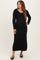 woman wearing a black long sleeve maternity dress with a fitted silhouette and shoulder tie details, showing a baby bump