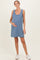 woman wearing a blue striped maternity dress and holding her baby bump