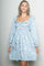 woman wearing a light blue lace long sleeve dress with a square neckline and a flared skirt