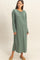 woman wearing a long sage green maxi dress with long sleeves and a side slit detail