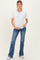 woman wearing a white short sleeve maternity top and blue flared jeans, holding her baby bump