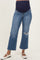 woman wearing a pair of blue maternity jeans with a wide leg and distressed details