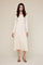 woman wearing a creamy off-the-shoulder ribbed midi dress with long sleeves and a fitted silhouette
