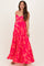 woman wearing a pink floral maternity maxi dress with adjustable spaghetti straps and flowing skirt, showing baby bump