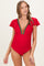 woman wearing a red maternity swimsuit with ruffle sleeves and colorful embroidery at the neckline