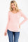 woman wearing a pink long sleeve henley top with button details and paired with blue jeans