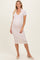 woman wearing a light pink maternity dress with a v-neck and short sleeves, showing her baby bump