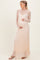woman wearing a peach lace maternity dress with long sleeves and a visible baby bump