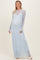 woman wearing a light blue lace maternity gown with long sleeves and a visible baby bump