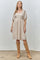 woman wearing a beige puff sleeve dress with a square neckline and knee-high tan suede boots