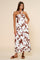 woman wearing a brown and white halter neck maxi dress with a floral pattern