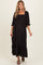 woman wearing a black floral maternity dress with puff sleeves and a ruffled hem, showing her baby bump