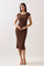 woman wearing a brown ribbed midi dress with white trim and short sleeves, standing against a neutral background