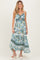 woman wearing a blue floral maternity maxi dress with a twist front and tiered skirt, showing her baby bump