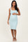 woman wearing a light blue ribbed maternity dress and holding her baby bump