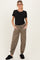 woman wearing a black maternity top and taupe ribbed maternity joggers with pockets, standing in cozy footwear