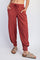 woman wearing rust-colored ribbed jogger pants with drawstring waist and side pockets