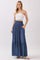 woman wearing a white strapless top and a long blue maxi skirt with buttons and pockets